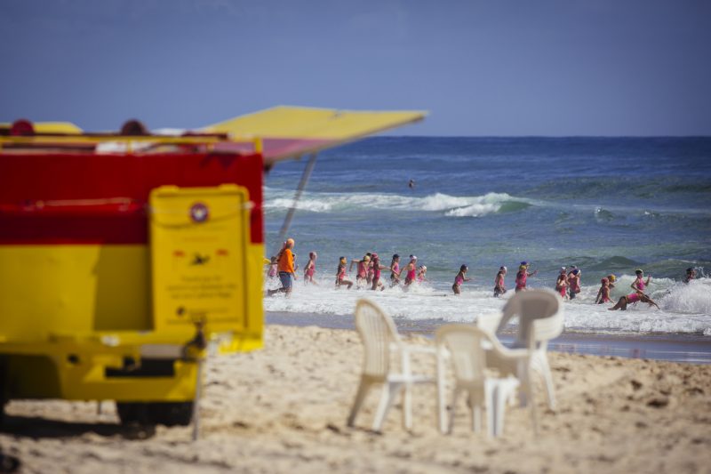 People swimming in the sea with the lifesavers watching